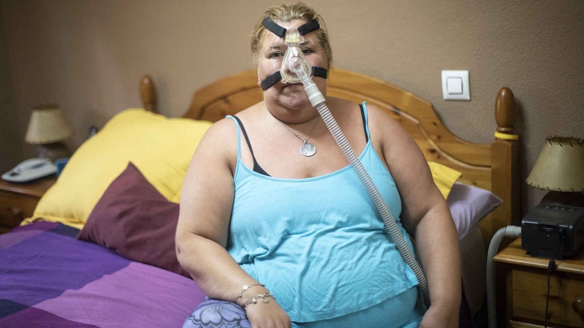 Arancha (44) posa con el respirador que necesita para dormir cada noche. Jorge Barreno