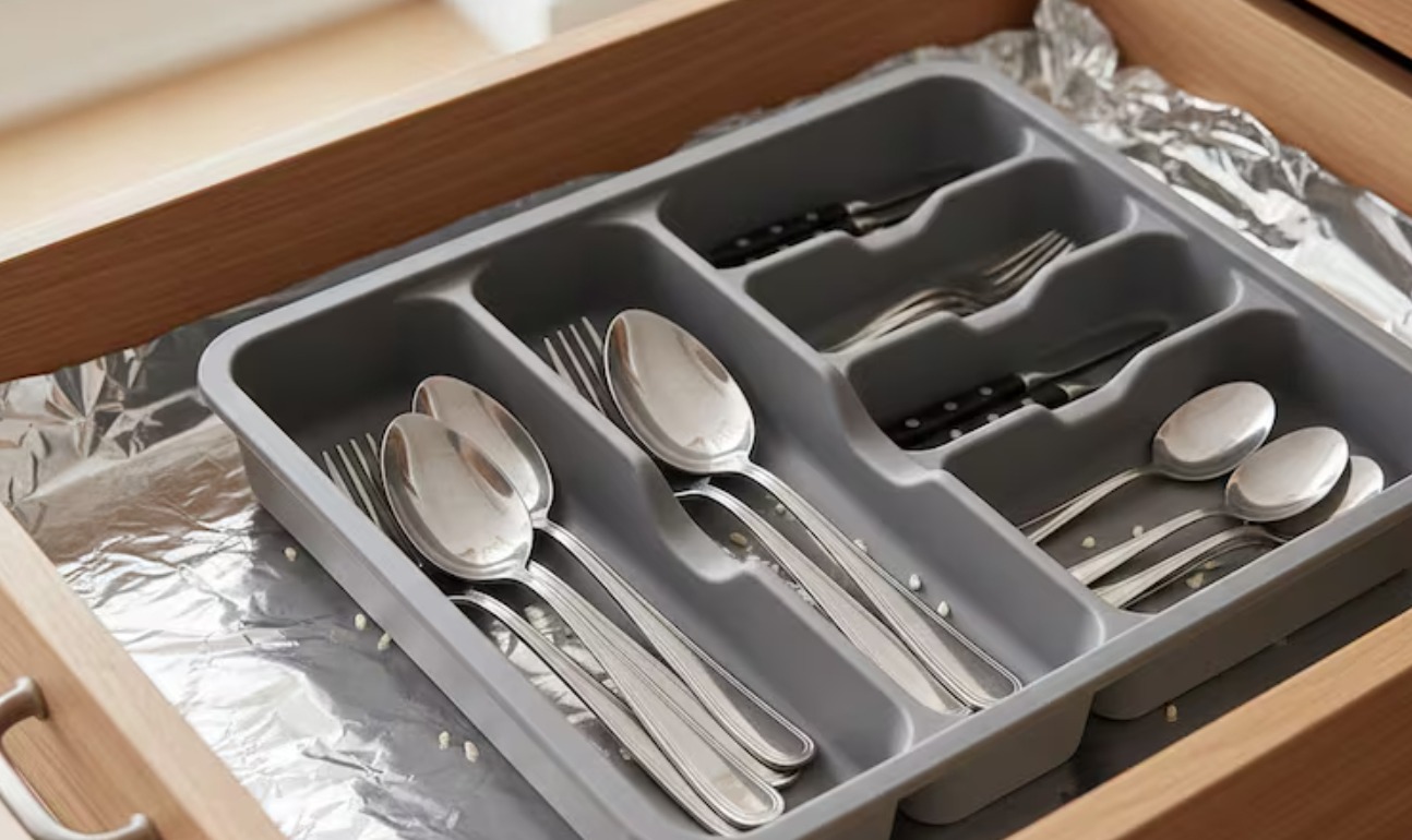 Cajón de cocina forrado con papel de aluminio con el lado brillante hacia arriba como truco casero para proteger la madera de la humedad y facilitar la limpieza según recomiendan miles de personas