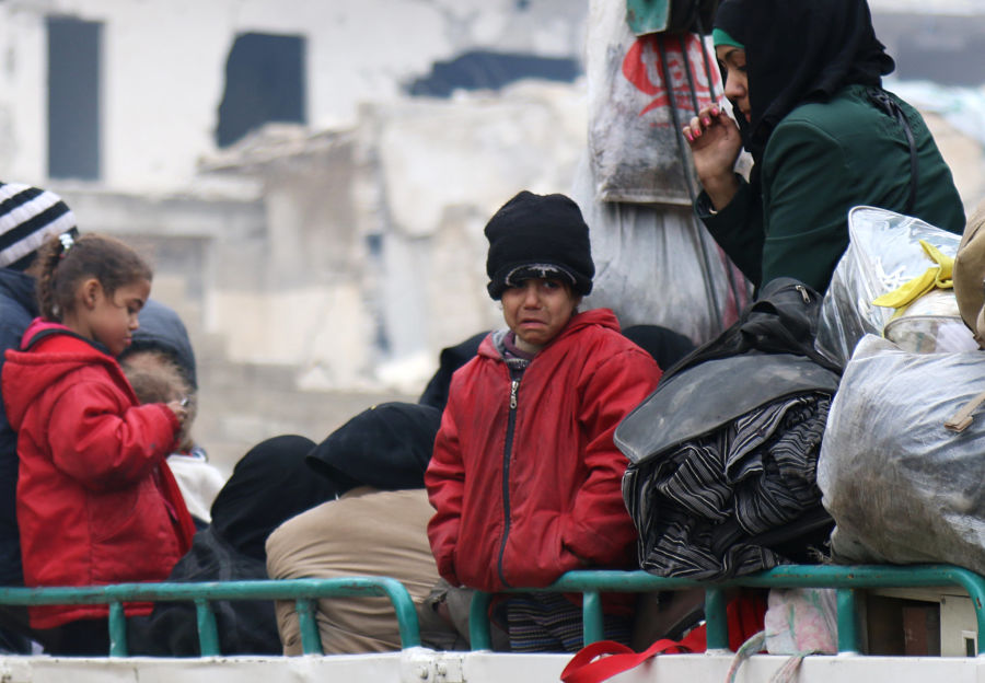Unos niños junto a otras personas en un camión a la espera de ser evacuados del sector rebelde de Alepo | REUTERS/Abdalrhman Ismail