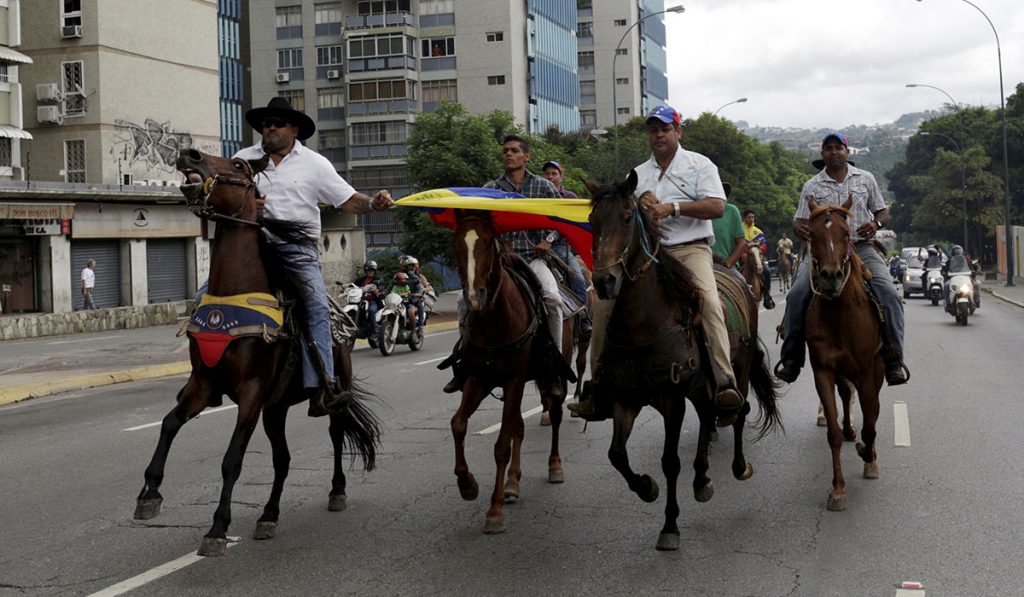 Opositores protestan a caballo en Venezuela. REUTERS/Marco Bello