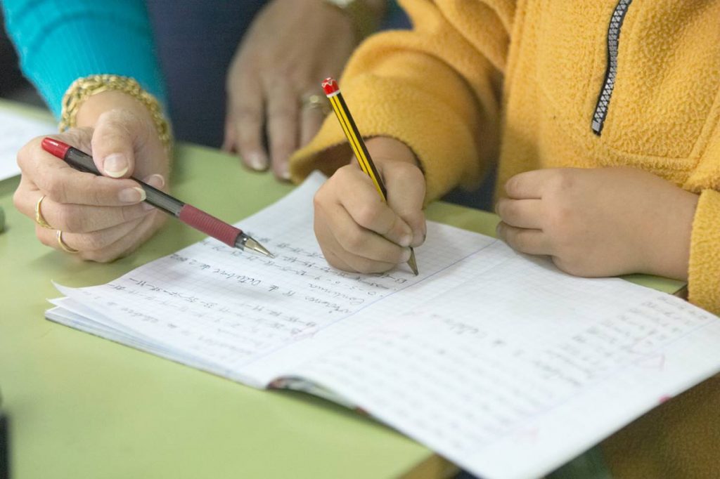 Una profesora atiende a un alumno durante una clase de Lengua Española. DA