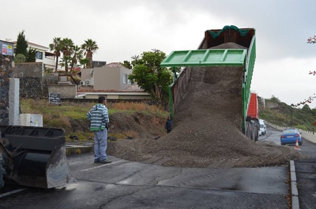Un operario junto a uno de los camiones que inician la construcción de la plataforma sobre la que irá la grúa. DA