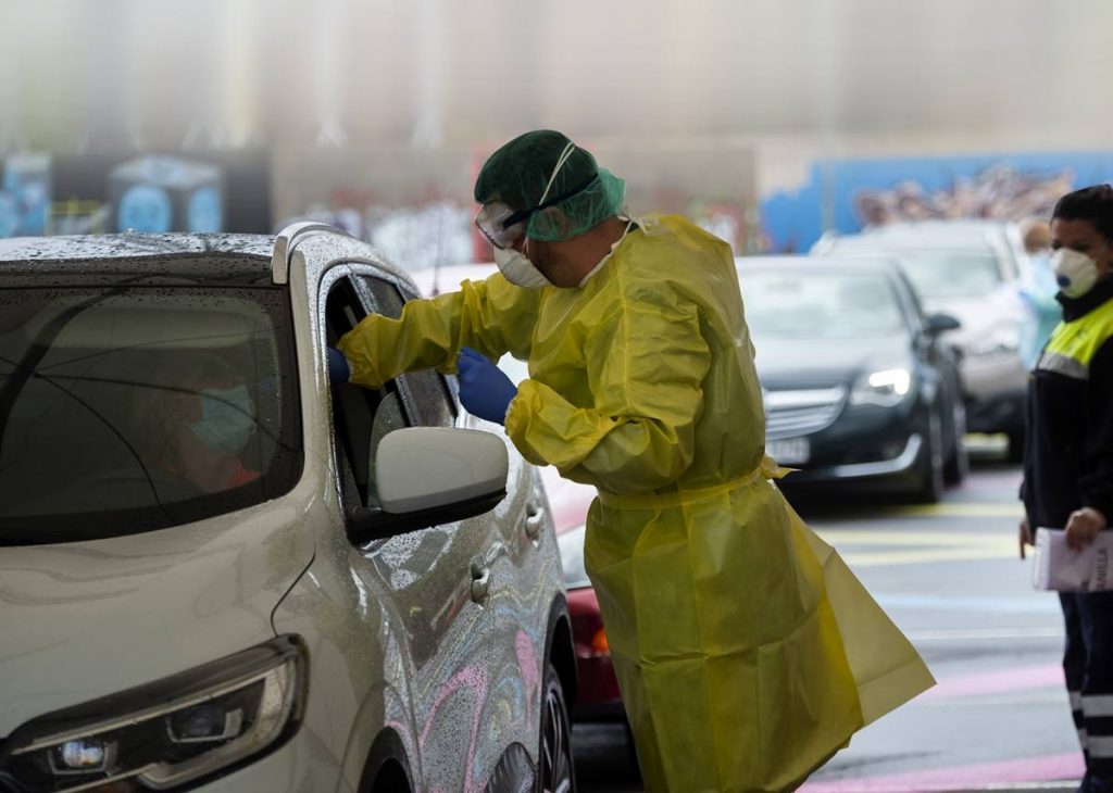Un miembro del equipo sanitario realiza una prueba a la conductora de un vehículo en el parking de la Facultad de Bellas Artes; El Archipiélago suma ya 287 contagios.