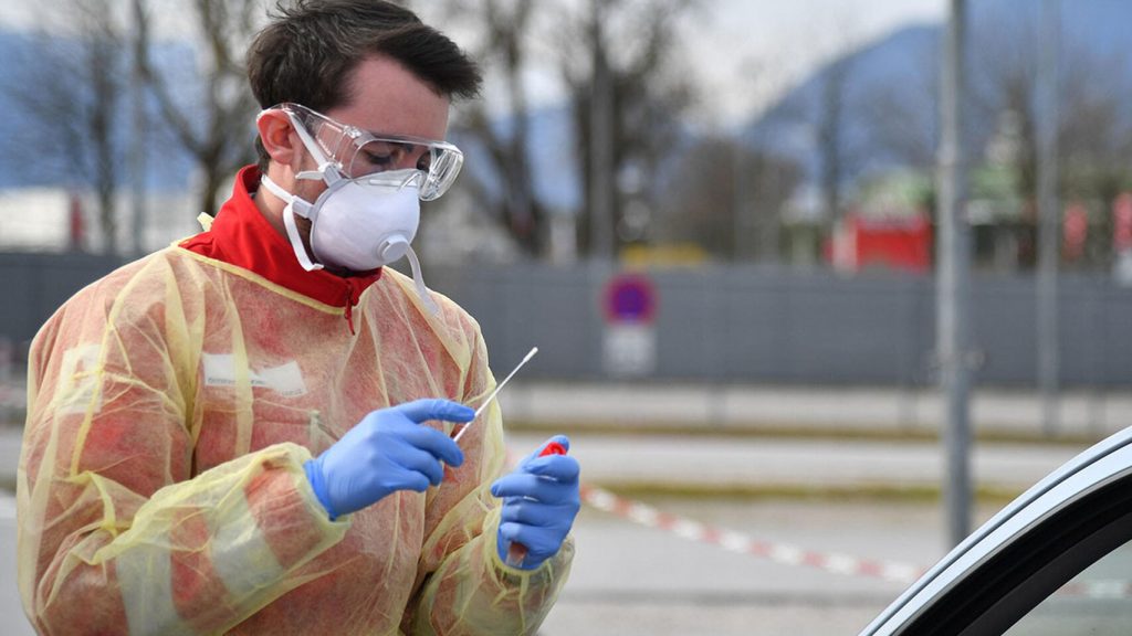 Un sanitario se dispone a tomar una muestra para un test de coronavirus. EFE
