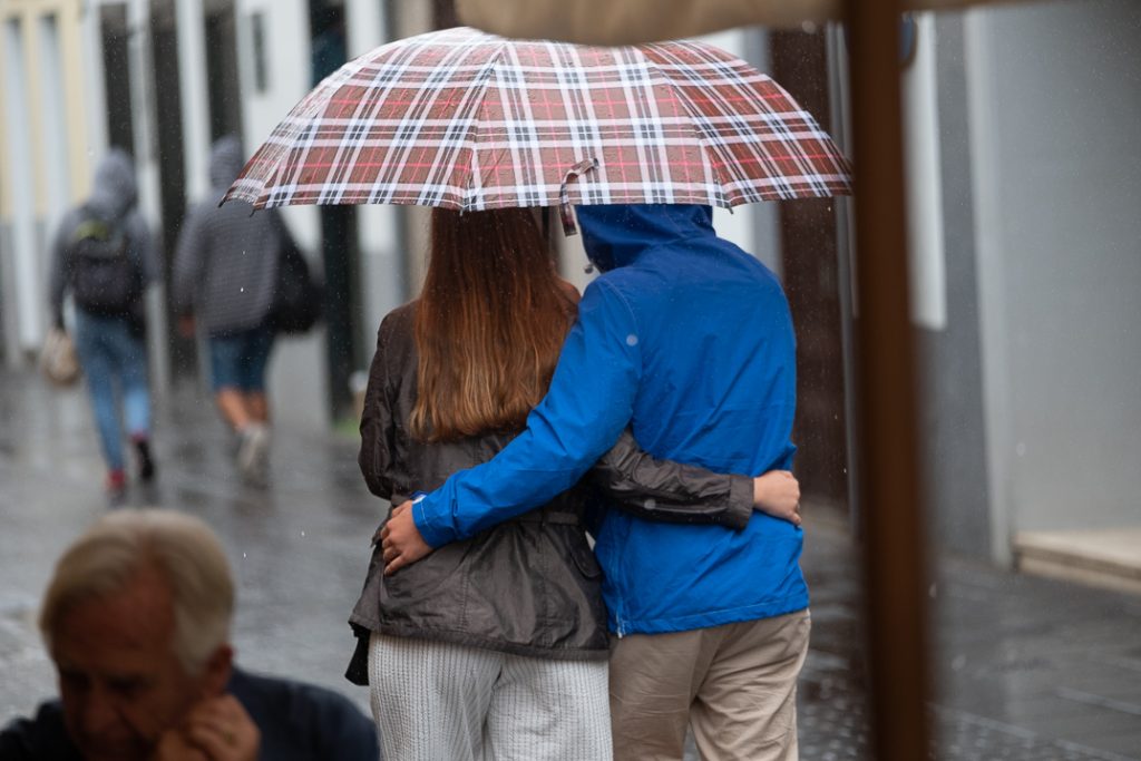 Dos personas se abrazan bajo un paraguas en La Laguna. FRAN PALLERO