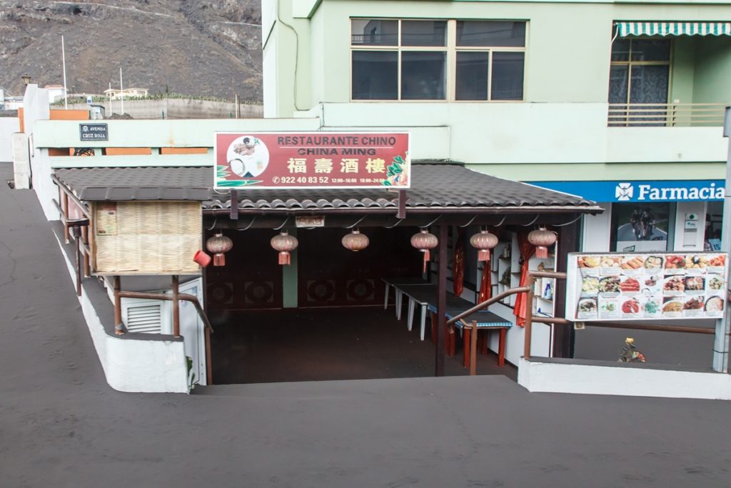 Un establecimiento cerrado en una vía cubierta de ceniza en Puerto Naos. EP