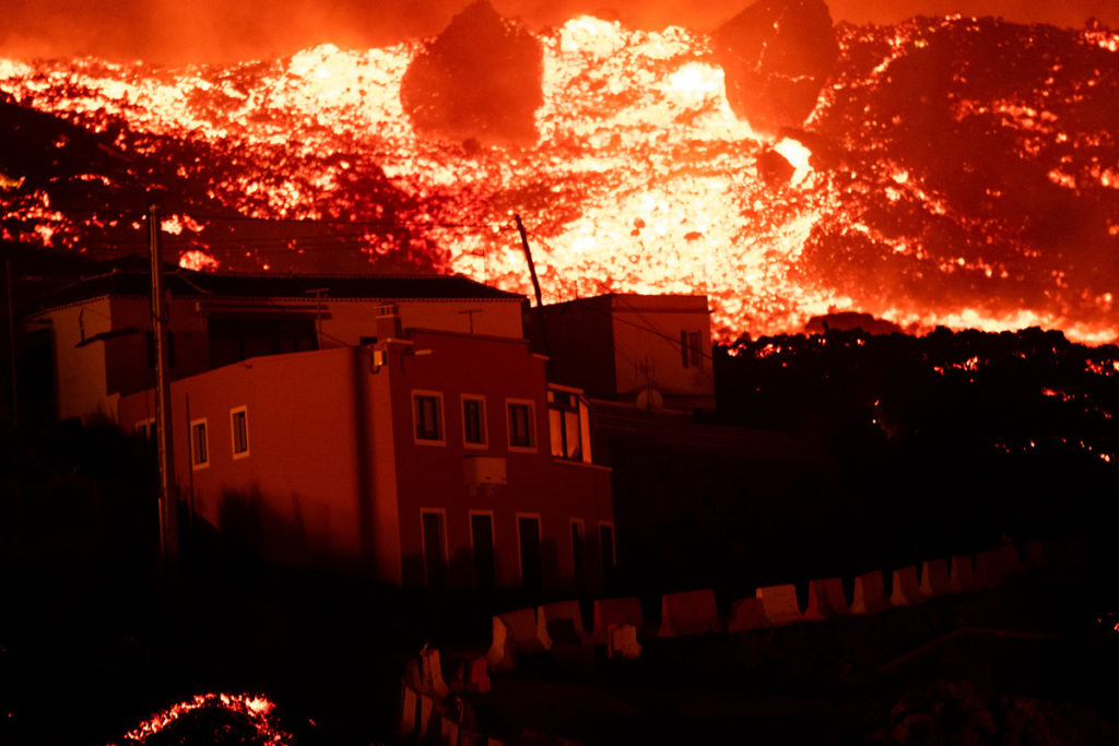 Imagen de archivo de una colada de lava que, amenazante, se cierne sobre unas viviendas palmeras. Fran Pallero