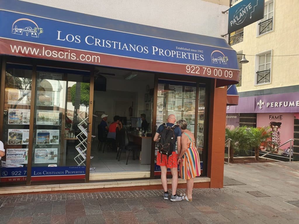 Varios turistas extranjeros, informándose ante una inmobiliaria en el centro de Los Cristianos.