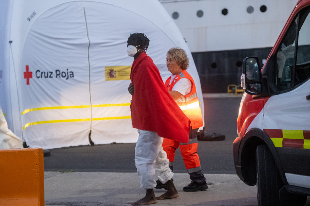 Un migrante es acompañado por una voluntaria. 