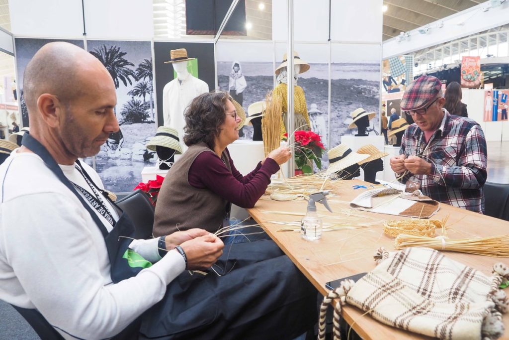 Varios artesanos presentes en la feria trabajando en sus oficios. 